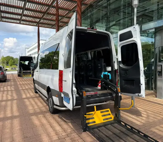 Professionele rolstoeltaxi chauffeur helpt klant in Haarlem
